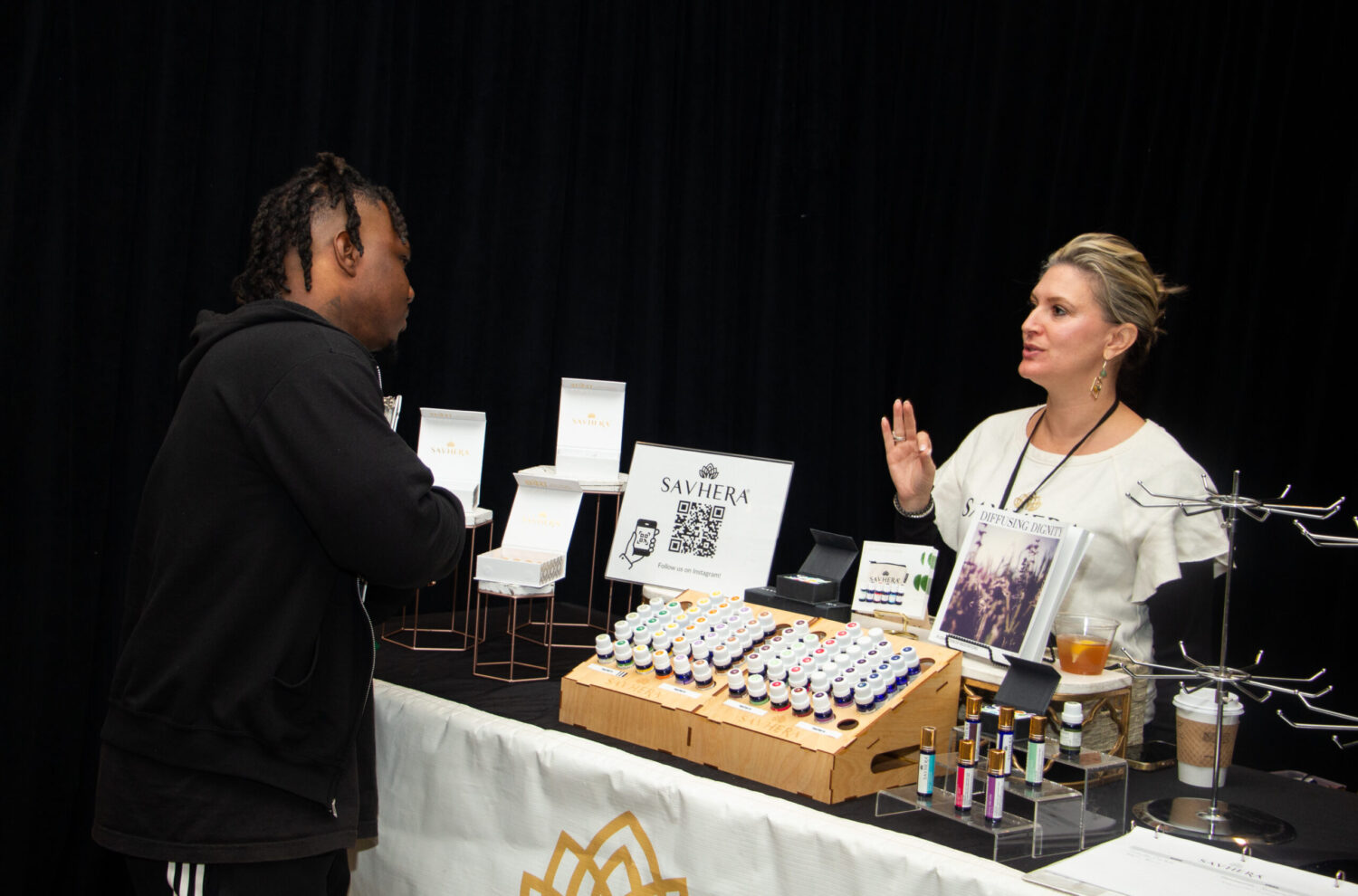 A conference attendee and a sponsor representative converse.