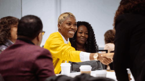 A woman shake hands during a conference session.